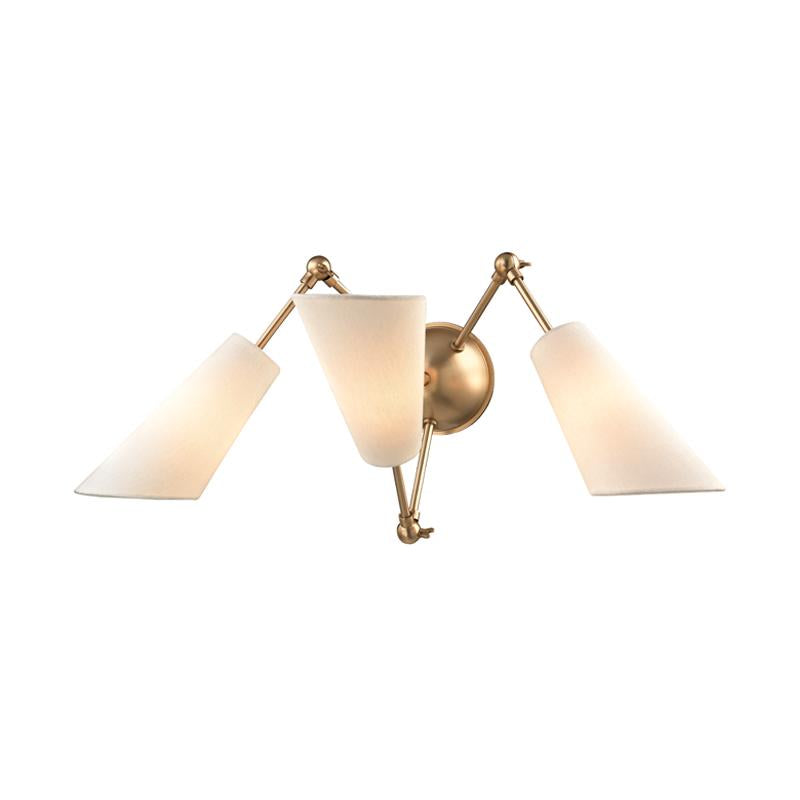 Buckingham three-light wall sconce in aged brass with adjustable arms and white fabric shades.