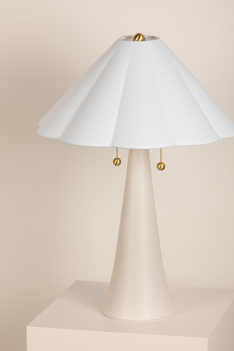 Alana table lamp with cream ceramic base, white scalloped linen shade, and brass ball pull chains.