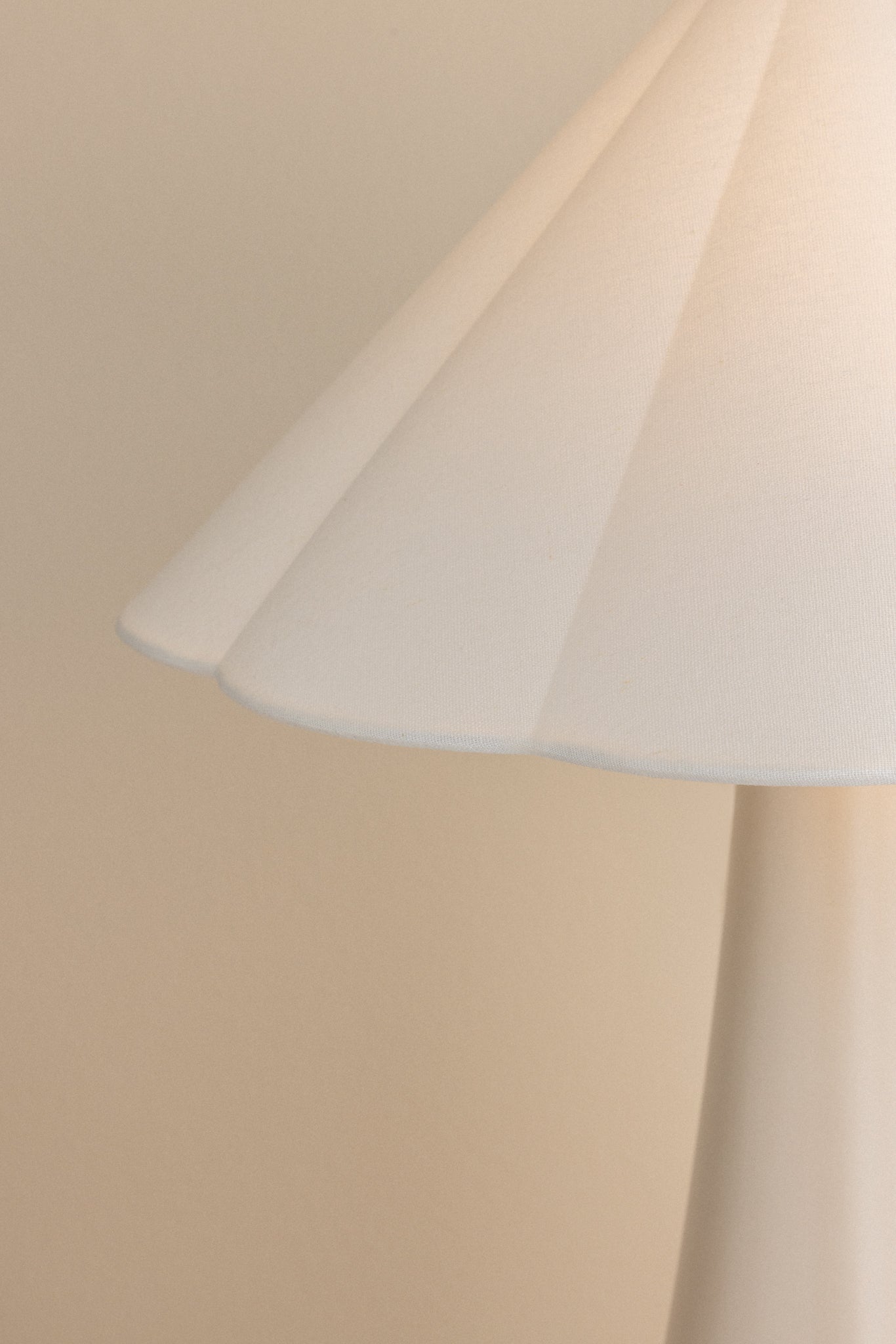 Close-up of the Alana Table Lamp featuring a white linen scalloped shade and ceramic base.
