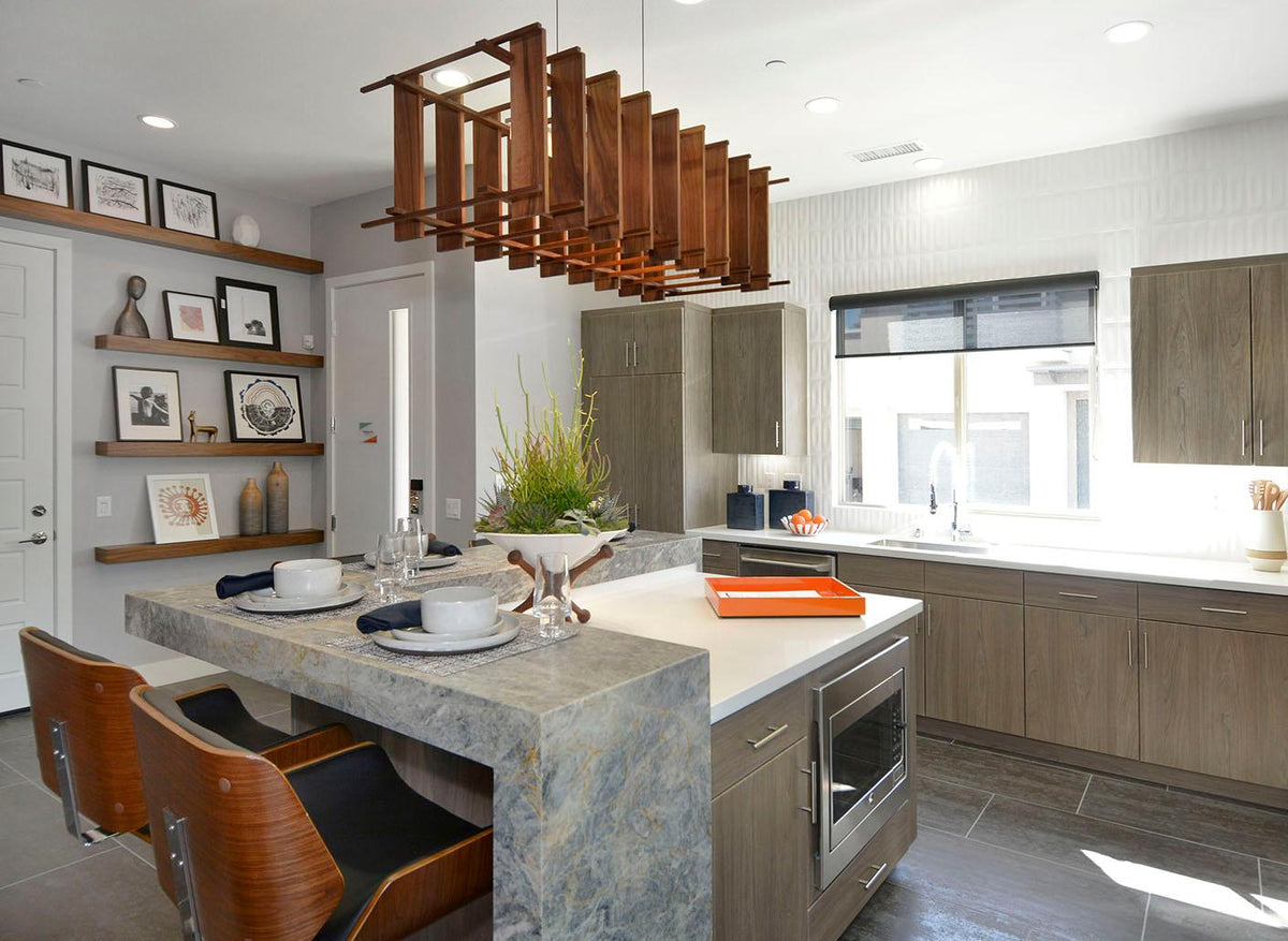 Arca walnut linear pendant chandelier hanging over a modern kitchen island.