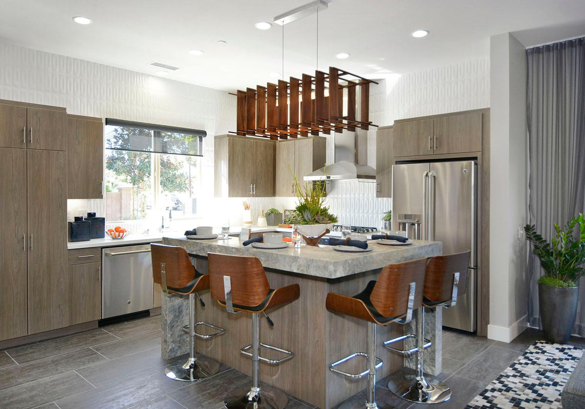 Arca walnut linear pendant chandelier hanging over a modern kitchen island.