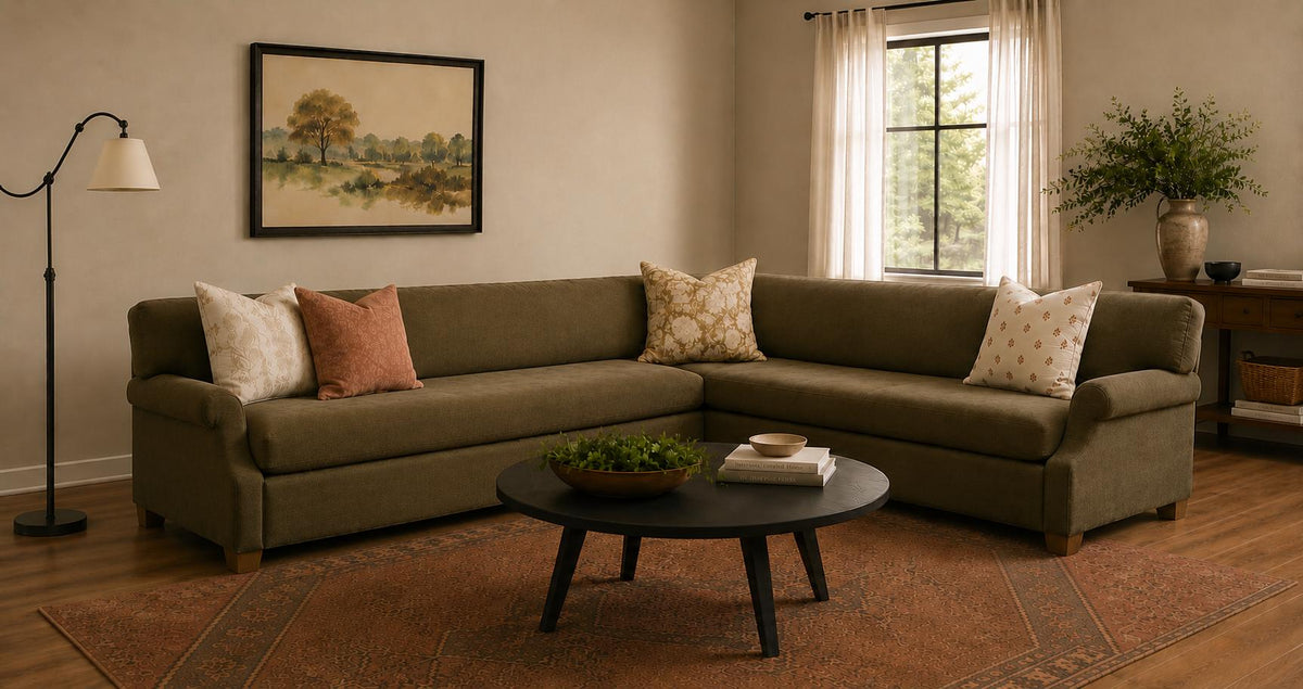 Elaida hand-woven jute and wool rug in rust and brown tones under a green sectional sofa.