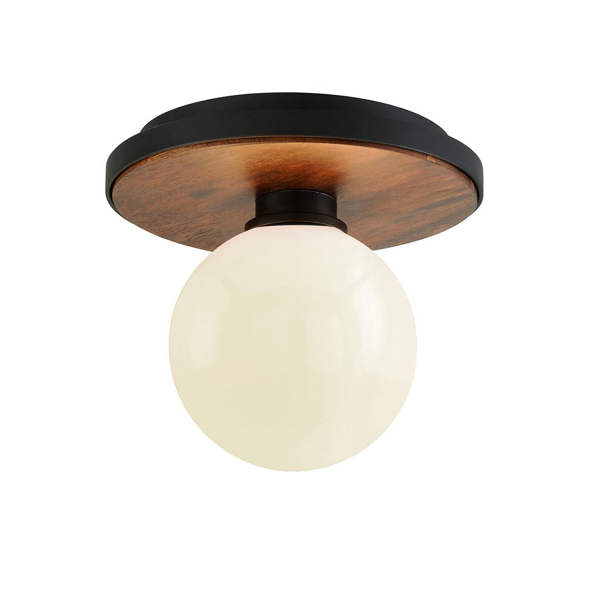 Cadet flush mount light with a round white glass globe, wood grain accent, and black metal base.