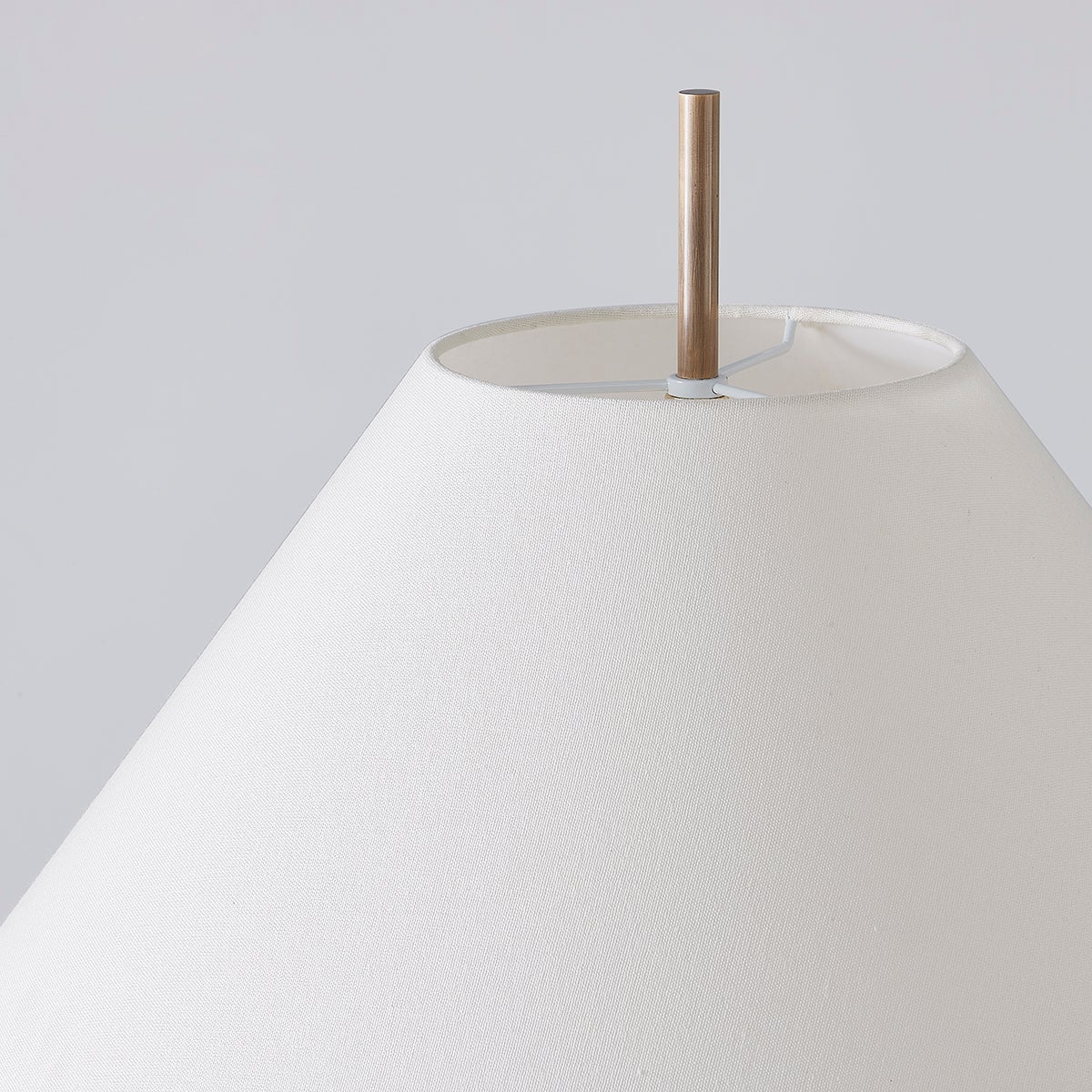 Clic floor lamp with a tapered off-white linen shade and patina brass pole.