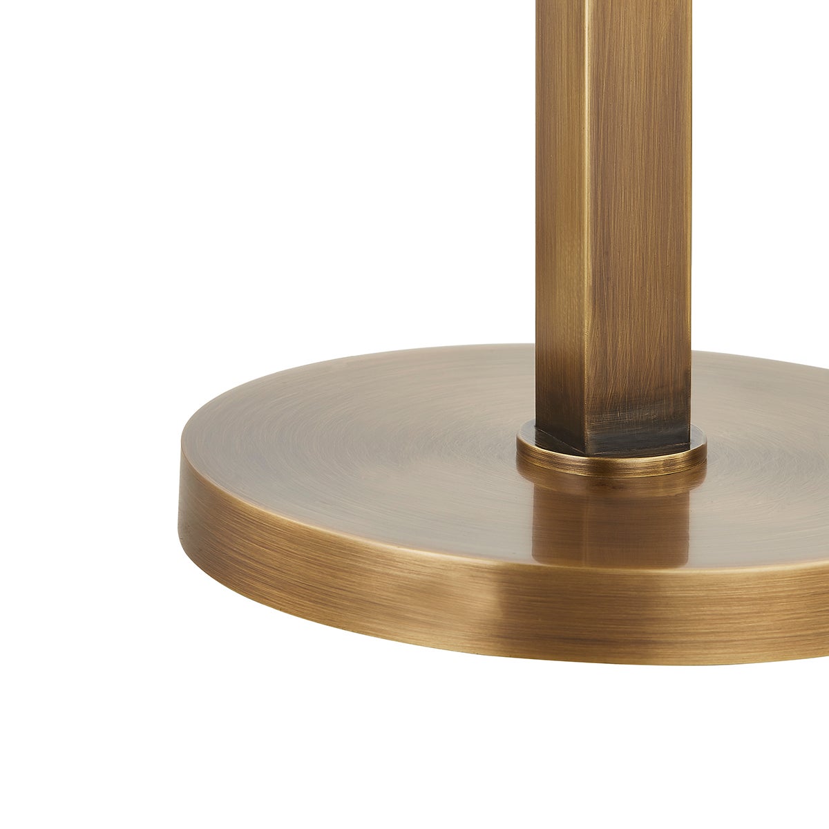 Close-up of the Clic table lamp's circular base and square body in patina brass finish.