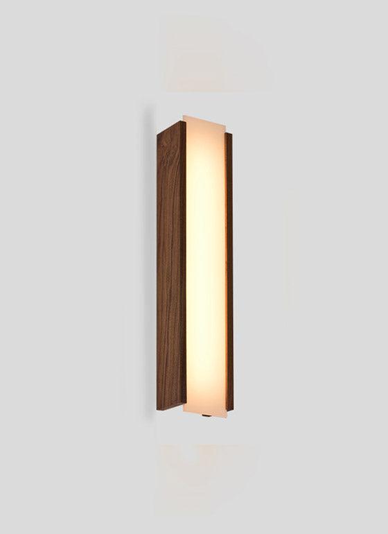 Capio solid walnut wood wall sconce with a glowing warm LED light panel.