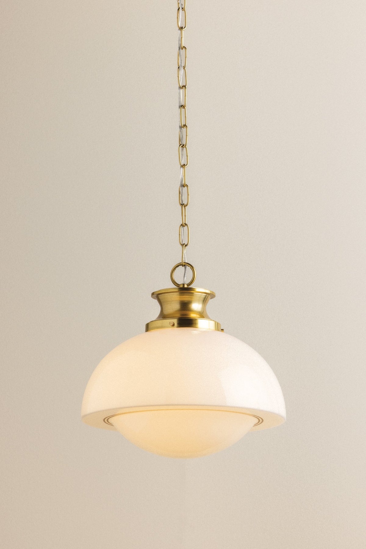 Celine mid-century pendant light with a domed opal glass shade and gold chain.
