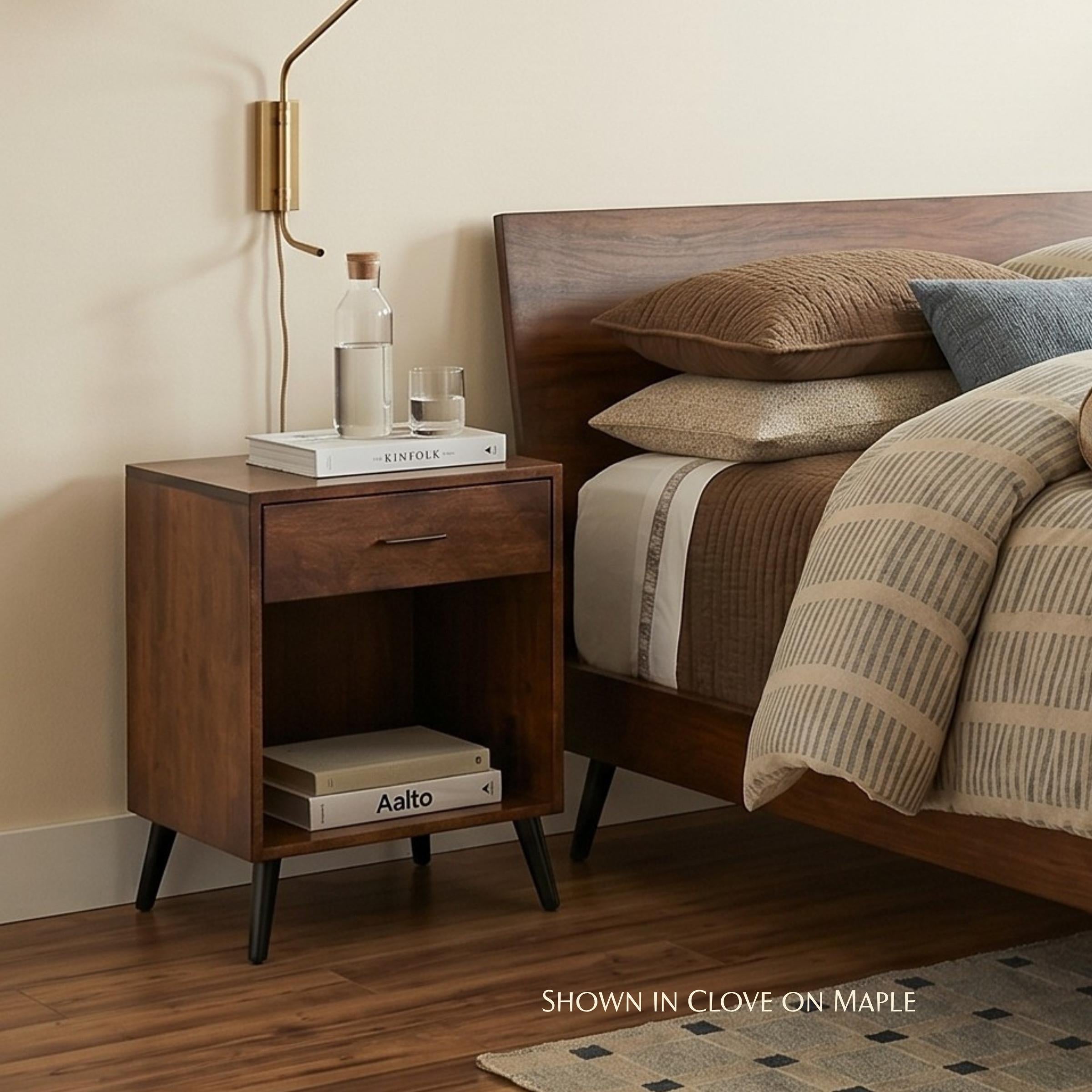 Bergen midcentury 1-drawer nightstand in clove on maple wood next to a bed
