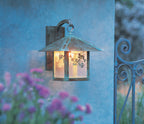 Evergreen Filigree wall mount lantern in verdigris patina with glowing gold white iridescent glass.