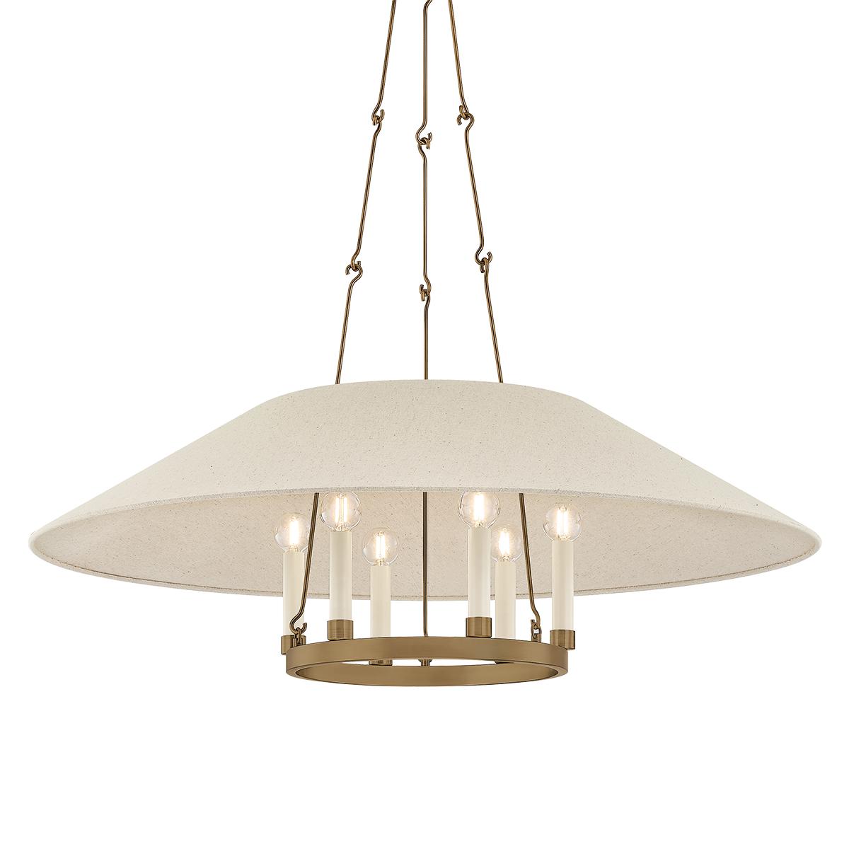 Archive Chandelier in Patina Brass with cream candle sleeves and a natural linen shade.