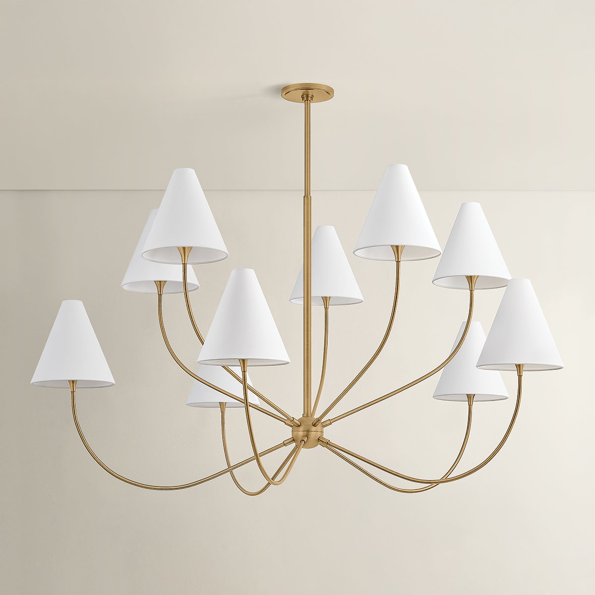 Evermore 10-light brass chandelier with arcing arms and white tapered shades.