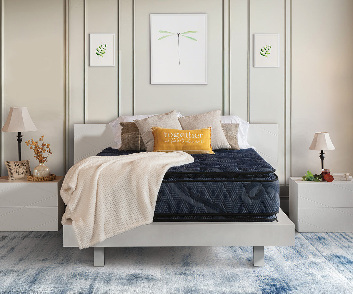Indulgence double-sided navy blue pillow top mattress on a modern white bed frame