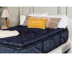 Indulgence 16-inch double-sided pillow top mattress in dark blue patterned fabric on a white bed frame.