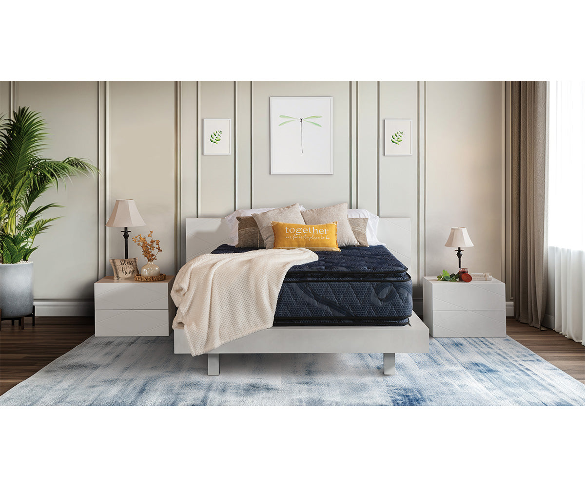 Indulgence navy blue pillow top mattress on a modern white bed frame in a styled bedroom.
