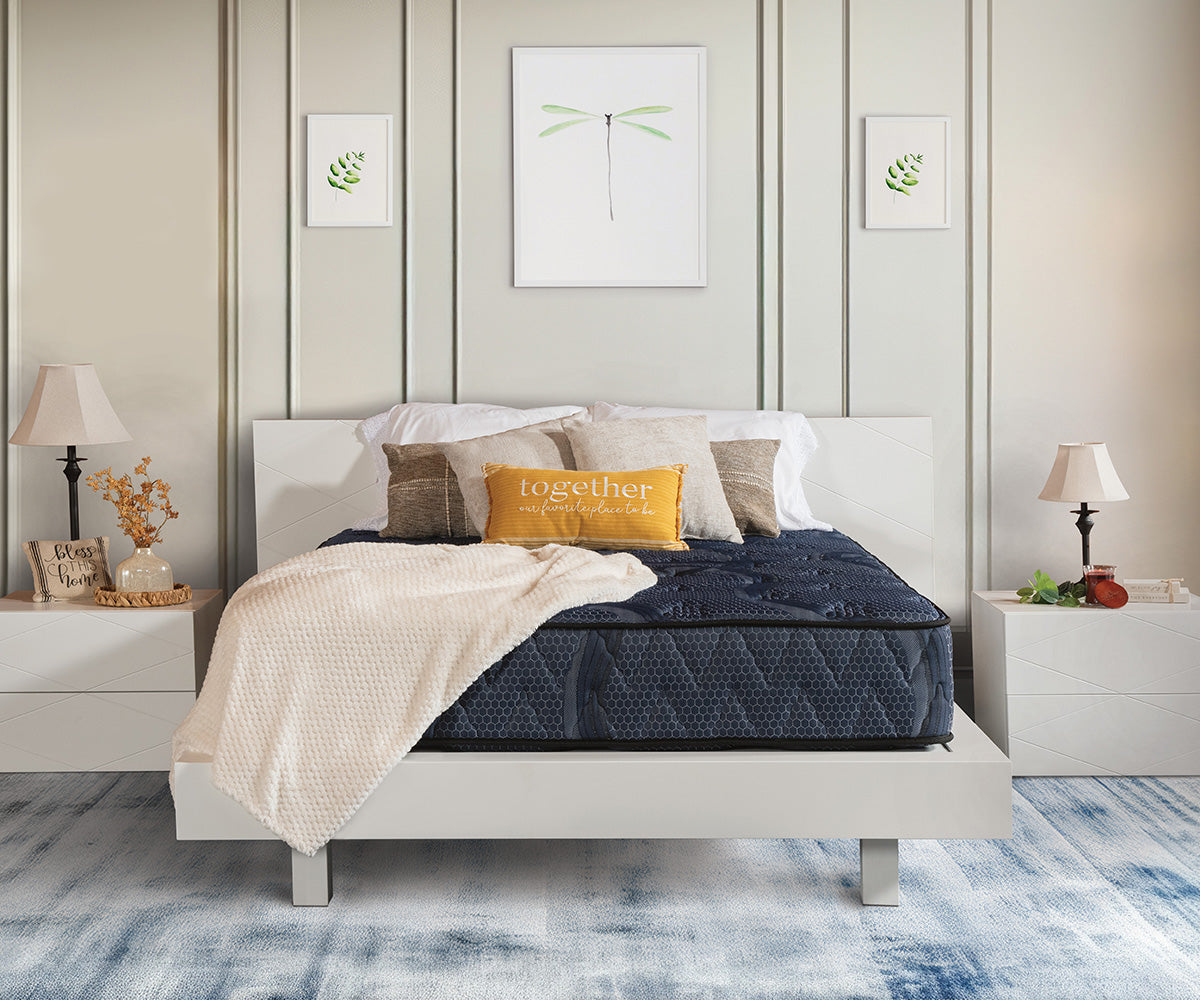 Siesta Mattress in dark blue quilted fabric on a white platform bed frame.