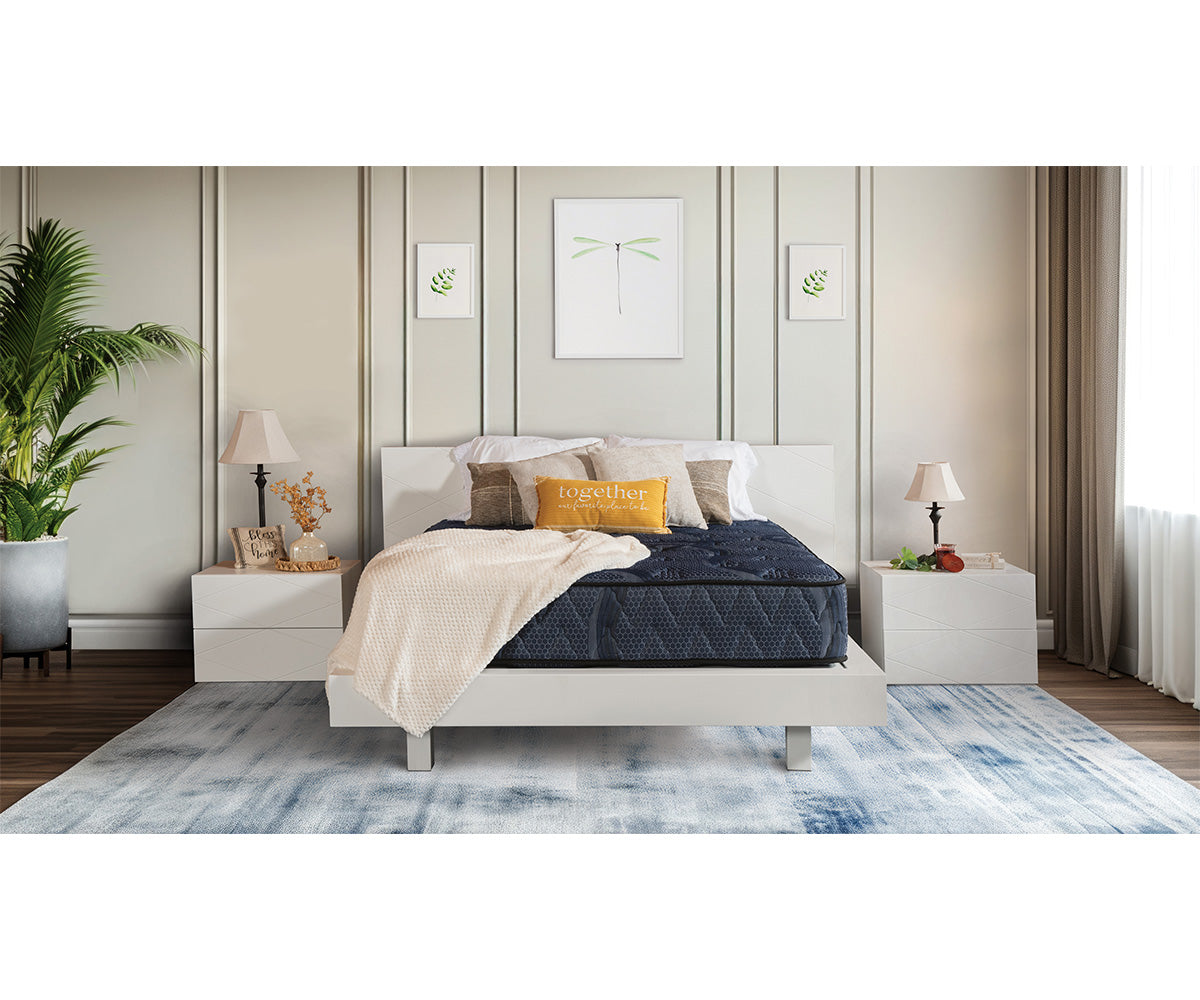 Dark blue Siesta Mattress on a white bed frame in a modern bedroom.