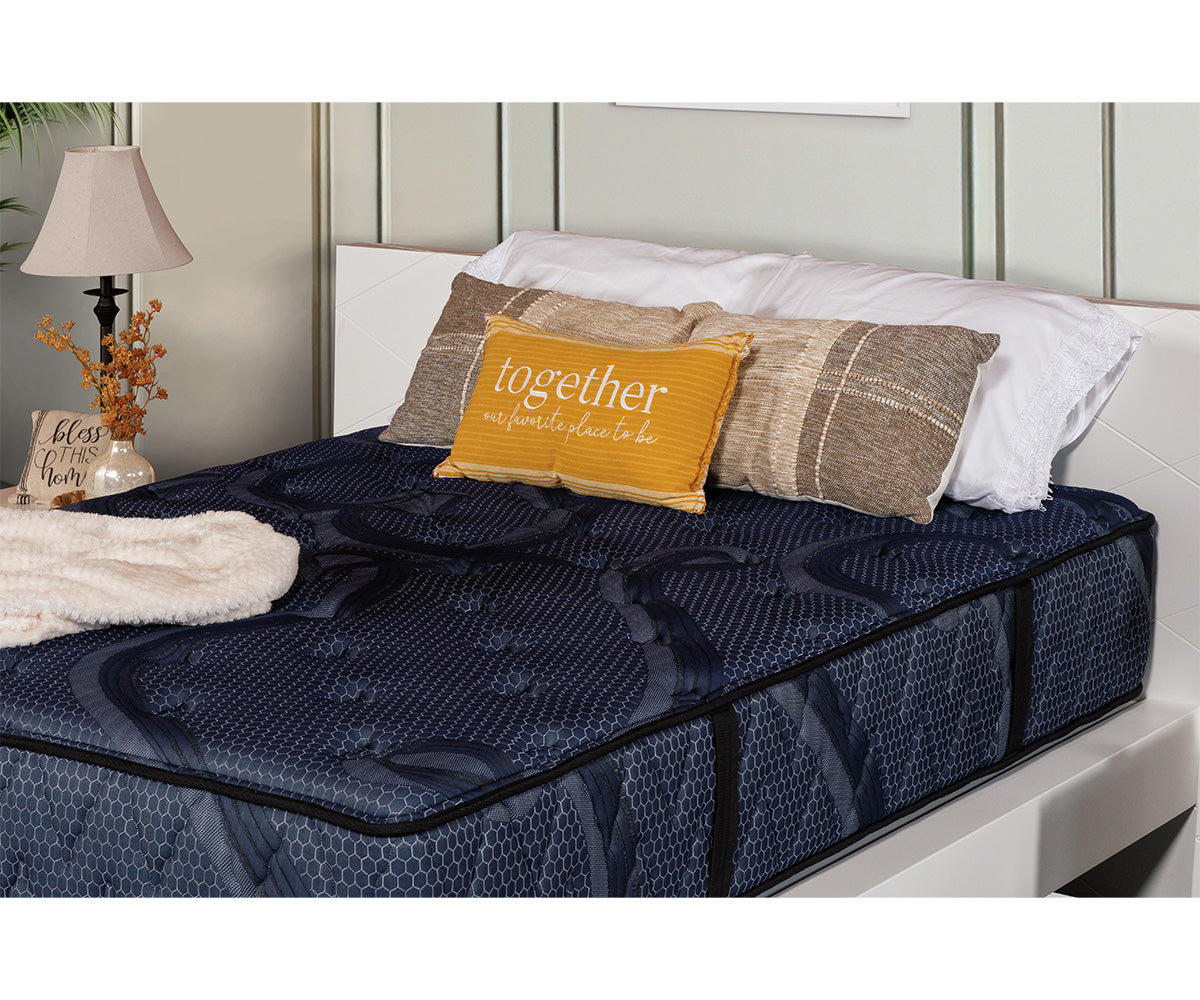 Splendor Mattress in dark blue quilted fabric with patterned details on a white bed frame.