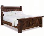 Rustic dark brown roughsawn wooden panel bed with white bedding and pillows.