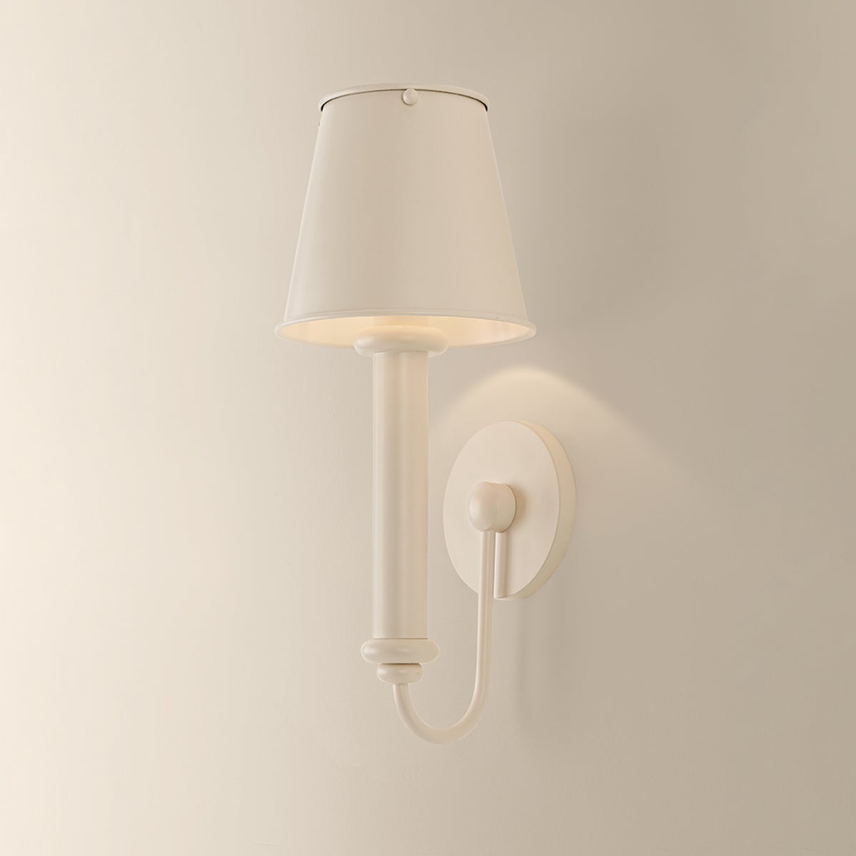 Yara wall sconce in soft bisque metal with a matching tapered shade.
