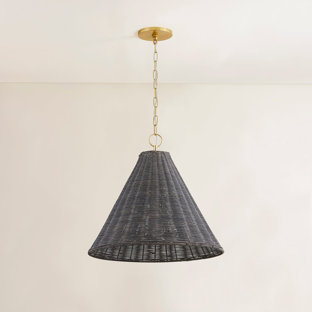 Destiny Pendant light with a conical gray wicker shade and aged brass chain.