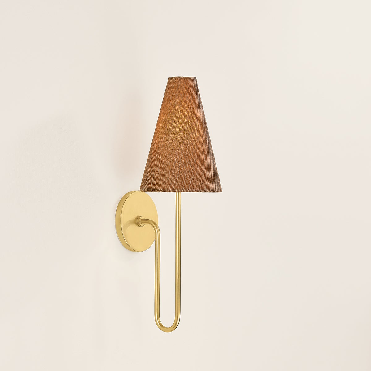 Jessel wall sconce with aged brass arm and woven grasscloth shade.