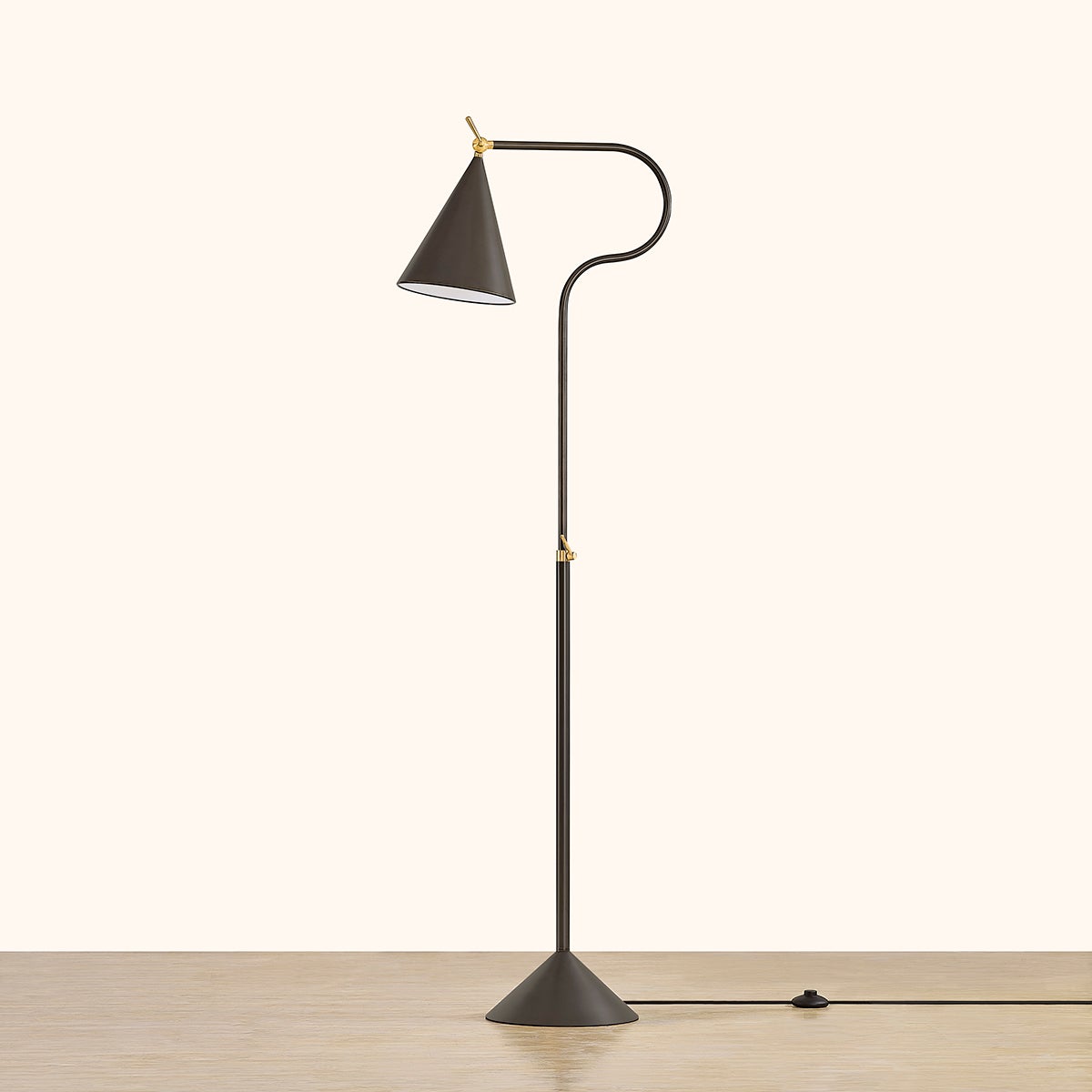Harriet modern black floor lamp with adjustable brass swivels and a conical shade.