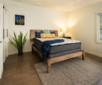 Emerald Mattress with a white quilted top and grey sides on a wooden bed frame.