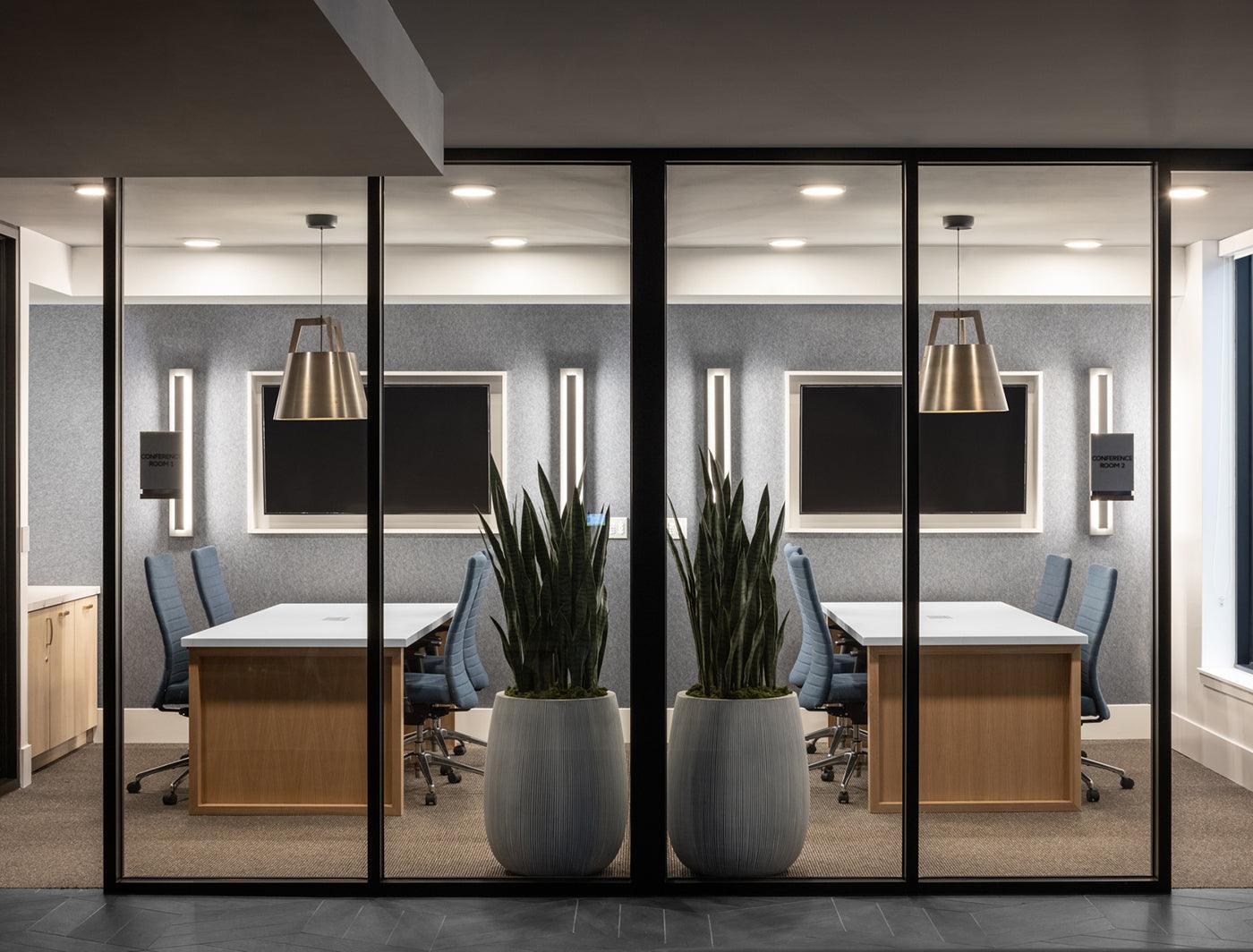 Imber brass pendant lights hanging in a modern office conference room.