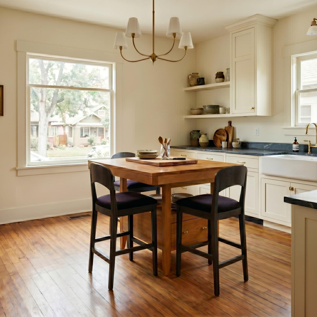 Justine solid hardwood island table with dark wood bar stools in a bright kitchen.