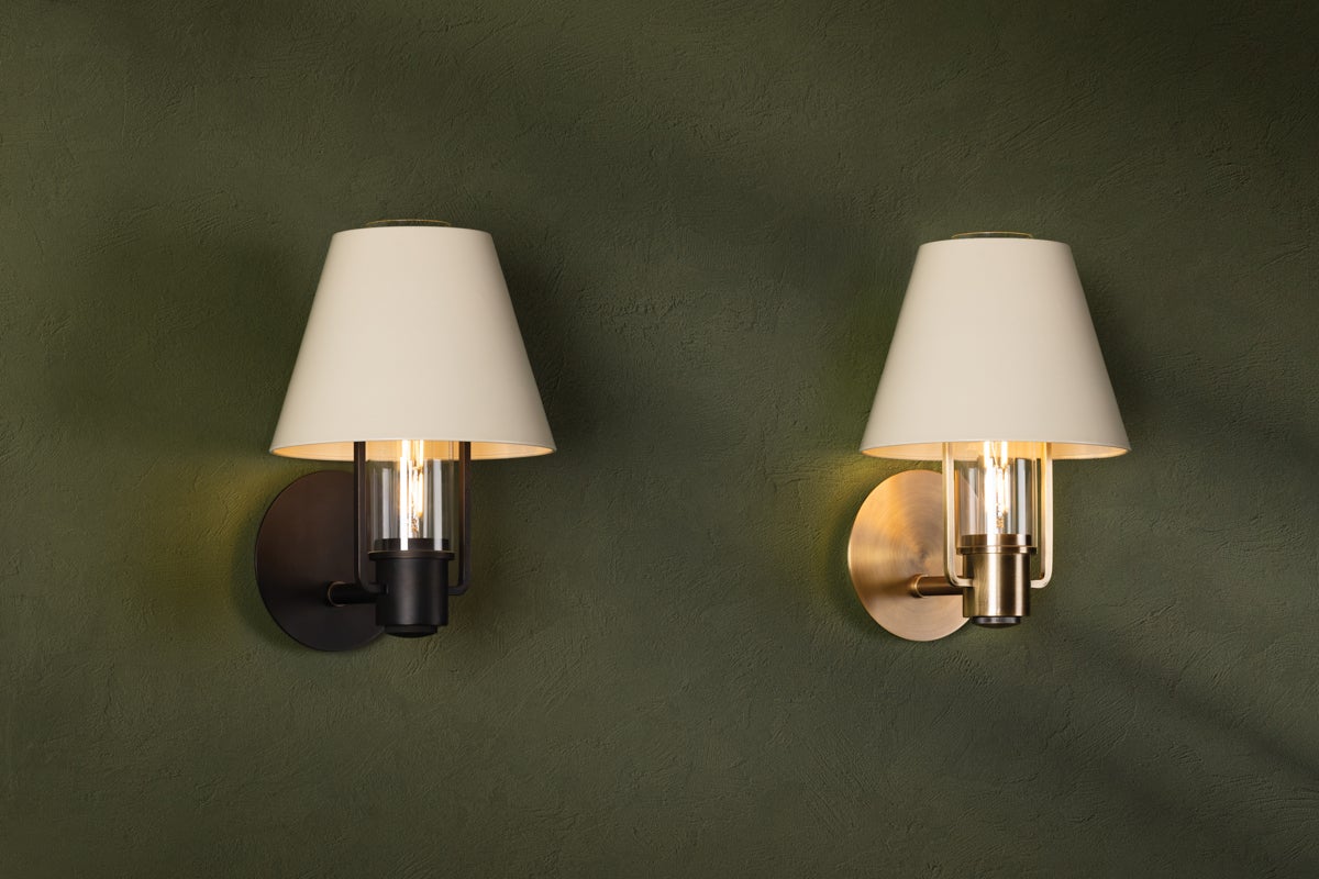 Kindle wall sconces in bronze and patina brass with tapered shades on a green wall