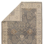 Liberty hand-knotted wool rug in muted grey and beige with traditional floral patterns and fringe.
