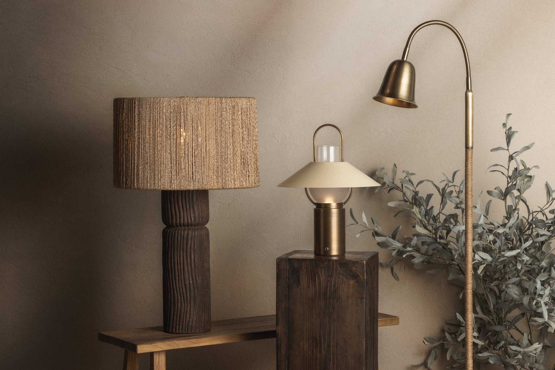 Wharf patina brass floor lamp with a jute-wrapped stem and adjustable gooseneck next to rustic table lamps.