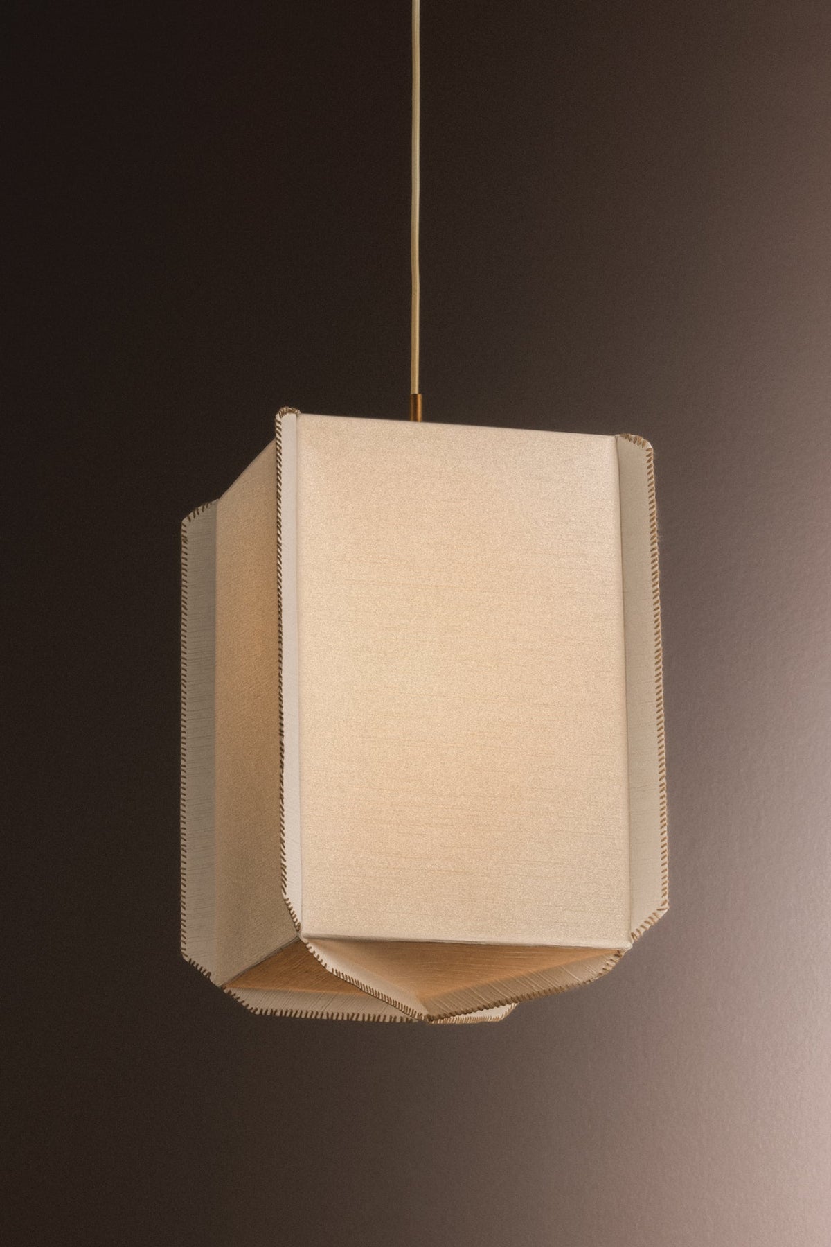 Louise rice paper pendant light with whipstitch edges and gold hardware.
