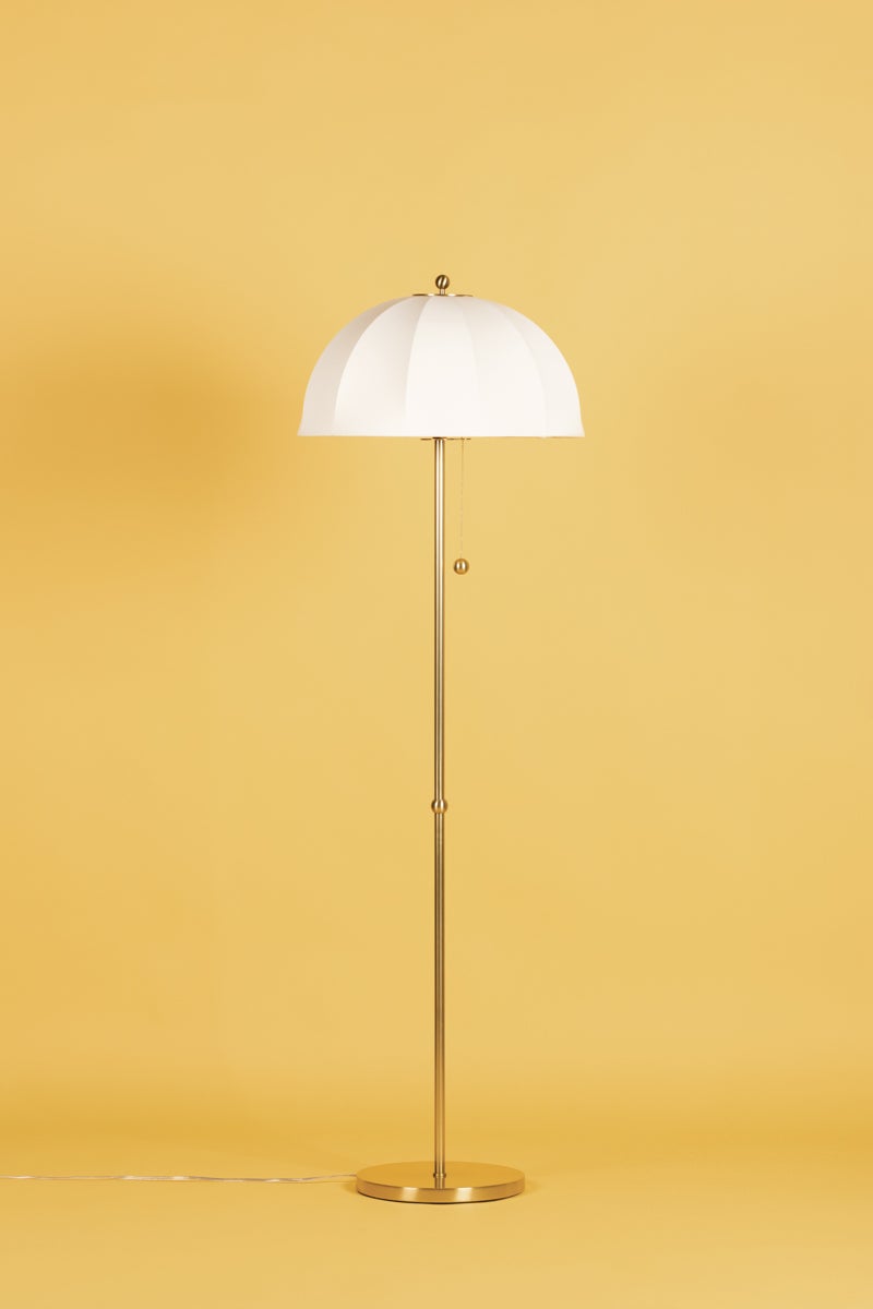 Meshelle floor lamp with white umbrella shade and aged brass stand on a yellow background.
