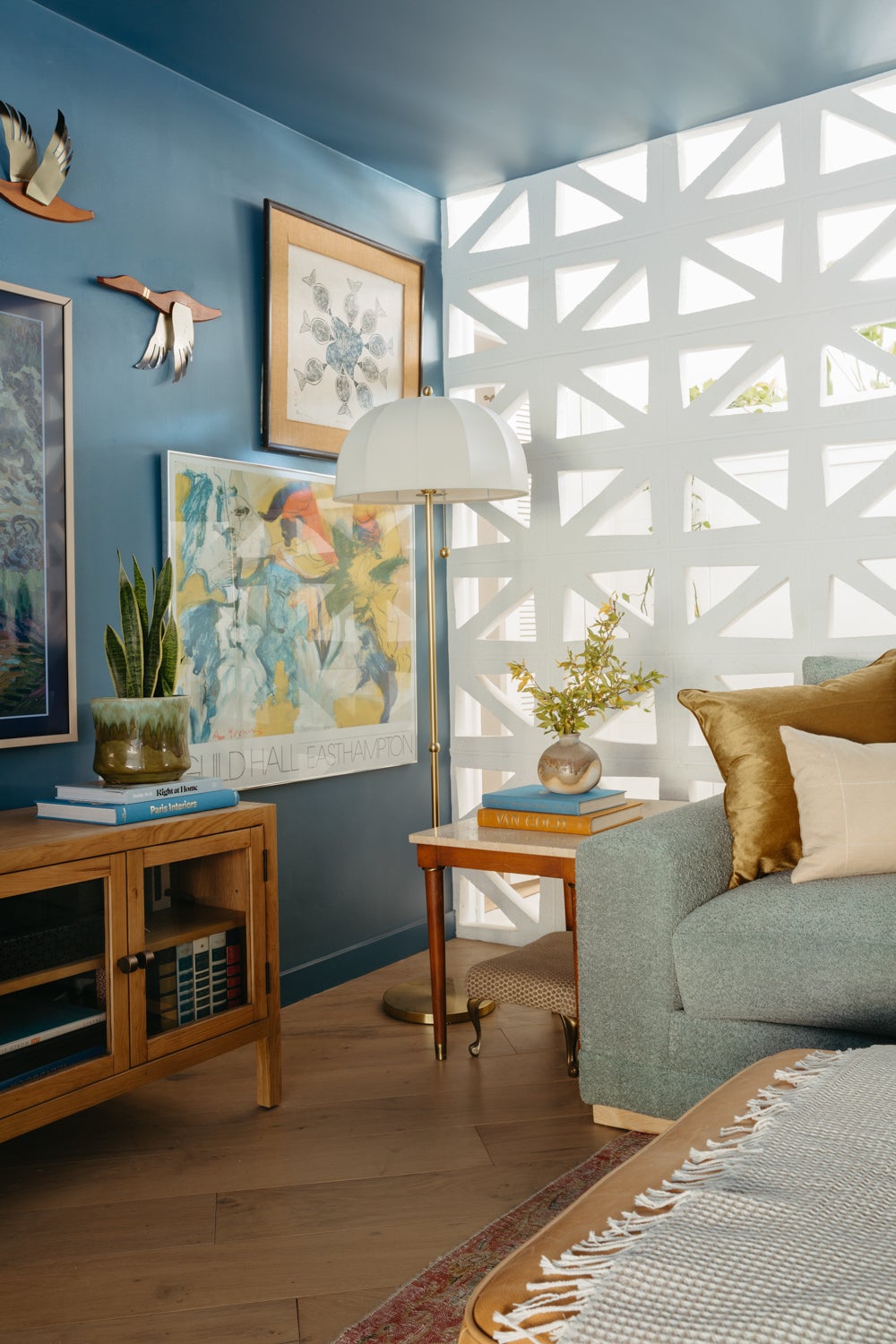 Meshelle mid-century floor lamp with a white umbrella shade and brass pole in a living room.