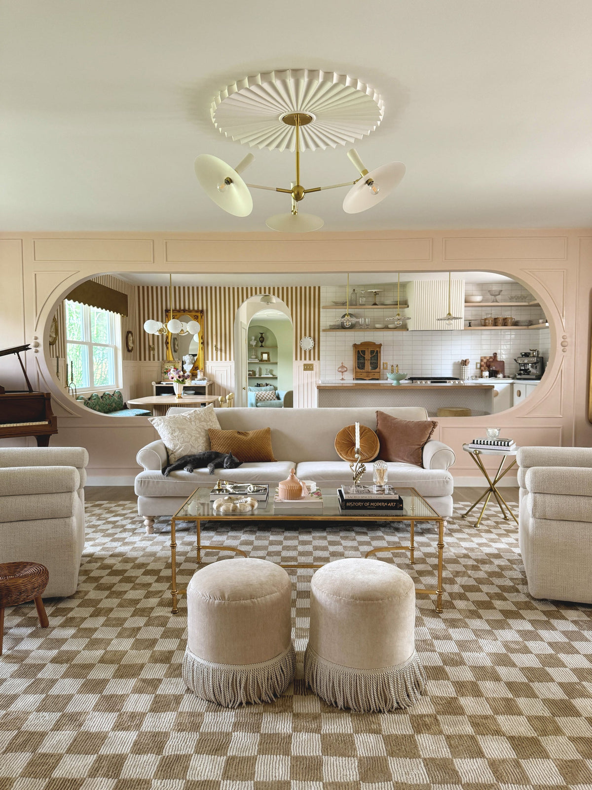 Tinsley Pendant light with white ceramic collar and aged brass pipe in a living room.