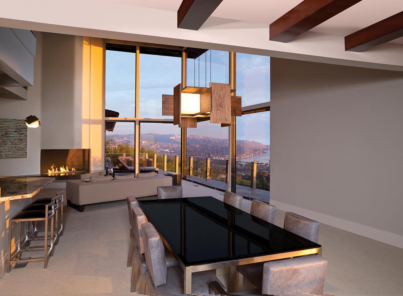 Muto walnut veneer pendant chandelier hanging over a dining table with a scenic view