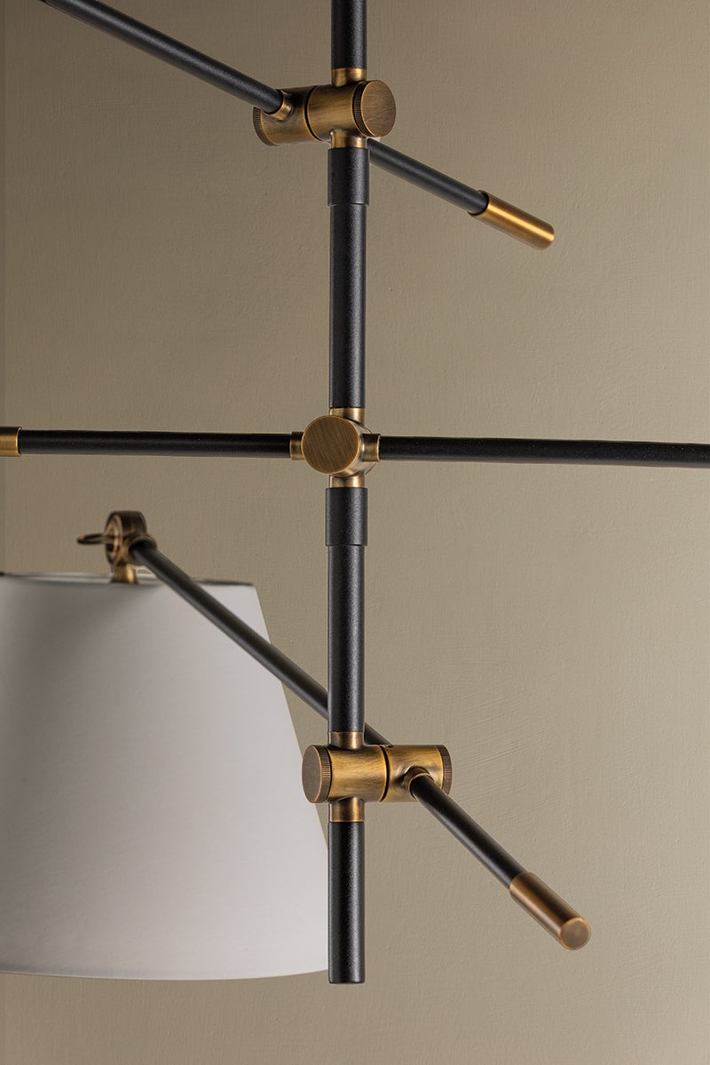 Navin Chandelier with textured black arms, patina brass joints, and a white linen shade.