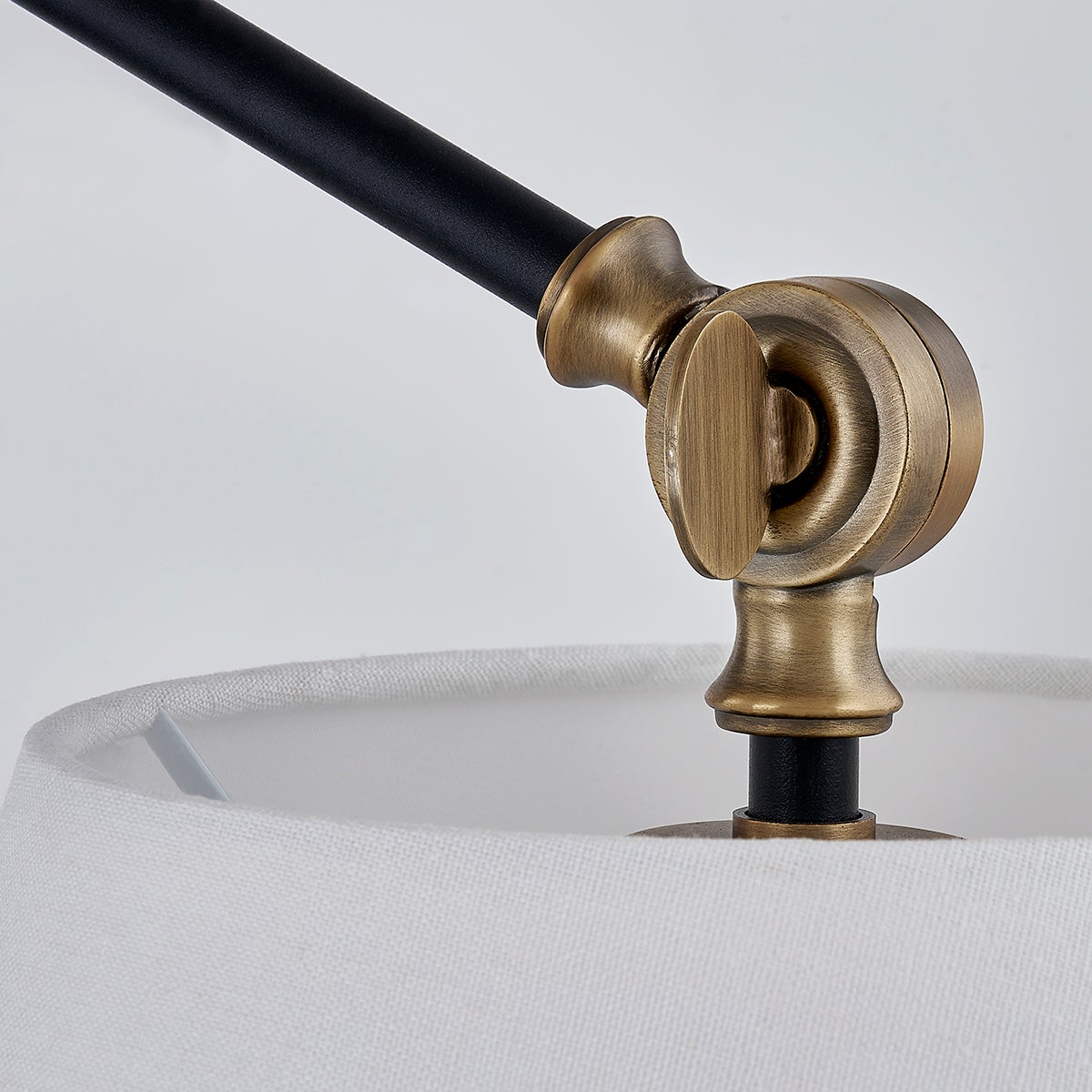 Navin chandelier adjustable patina brass joint with black arm and white linen shade.