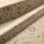 Orenda hand-knotted wool rug in beige with muted floral patterns.