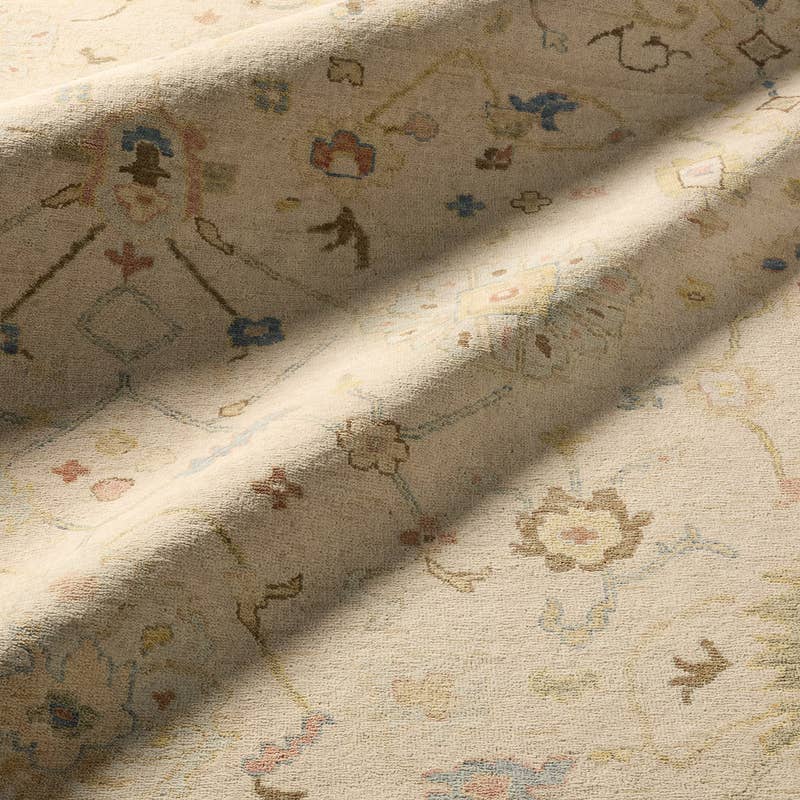 Orenda hand-knotted wool rug in beige with muted floral patterns.