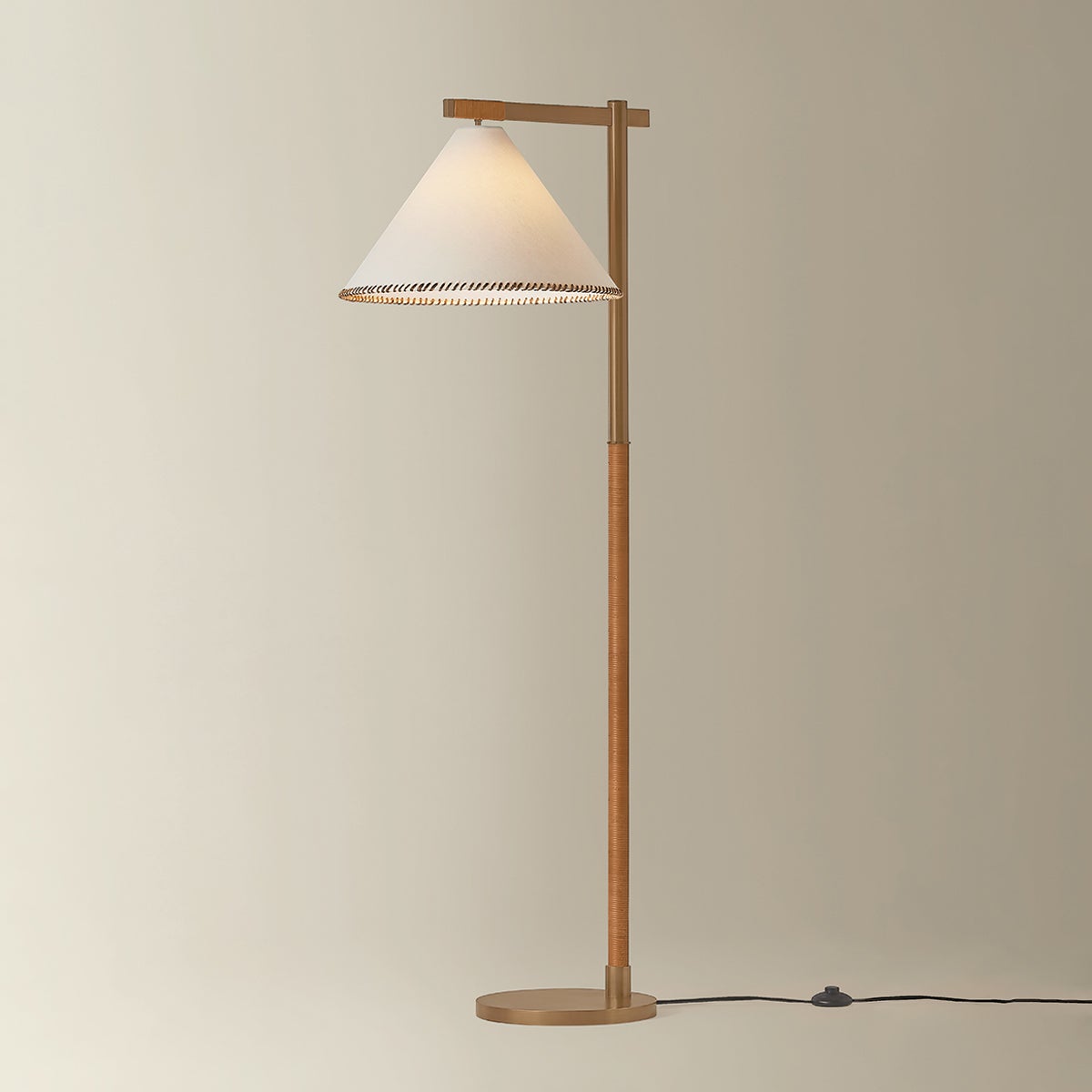 Stoney floor lamp with brass frame, jute wrap detail, and whip-stitched white linen shade.