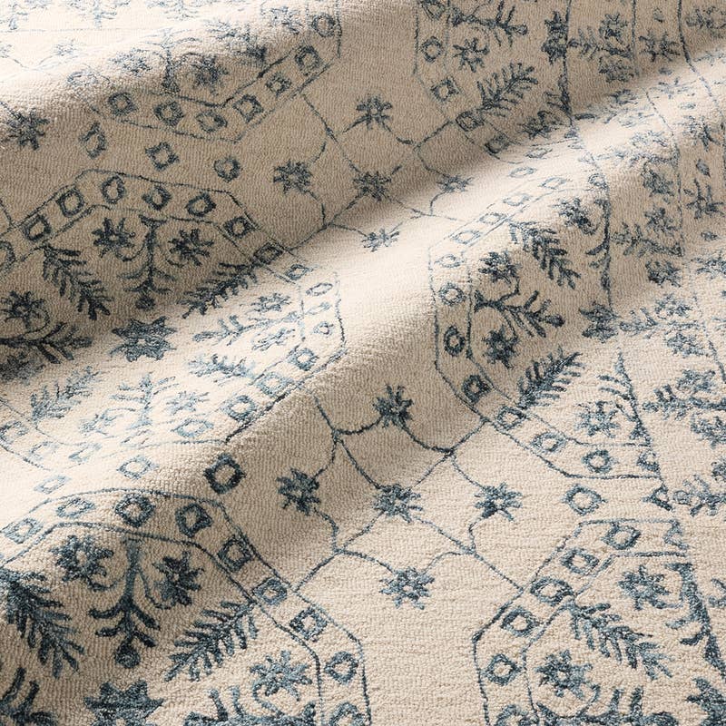 Province hand-tufted wool rug with a blue botanical pattern on a cream background.