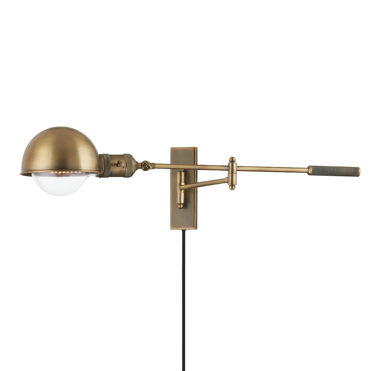Cannon adjustable wall lamp in patina brass with a dome shade and long swing arm.