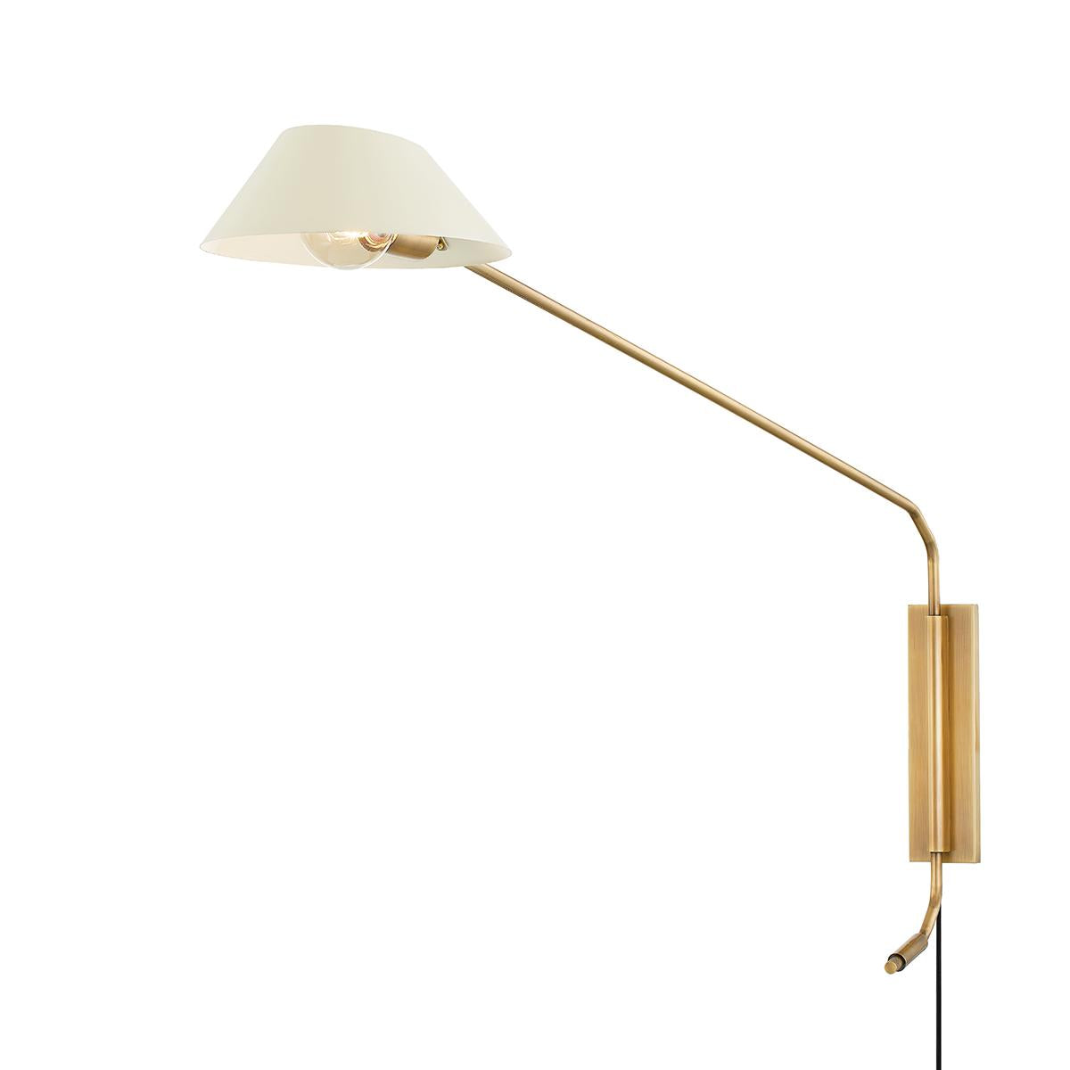 Sacramento plug-in sconce with a soft sand metal shade and a long patina brass swing arm.