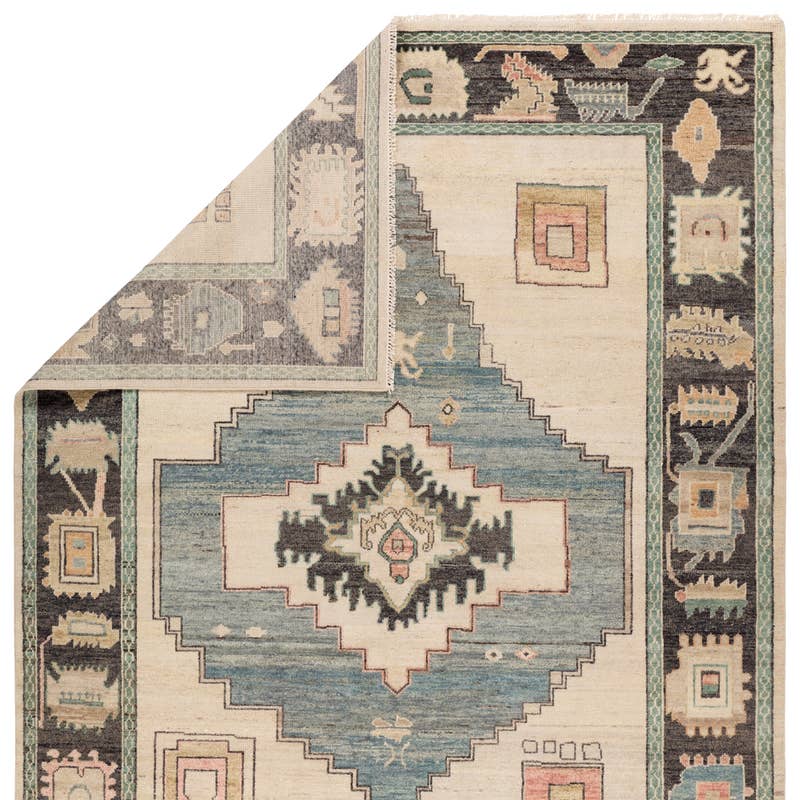 Reza hand-knotted wool rug with blue, cream, and dark grey geometric patterns.