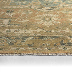 Rhapsody Orange hand-knotted wool and viscose rug with muted floral patterns and fringe.