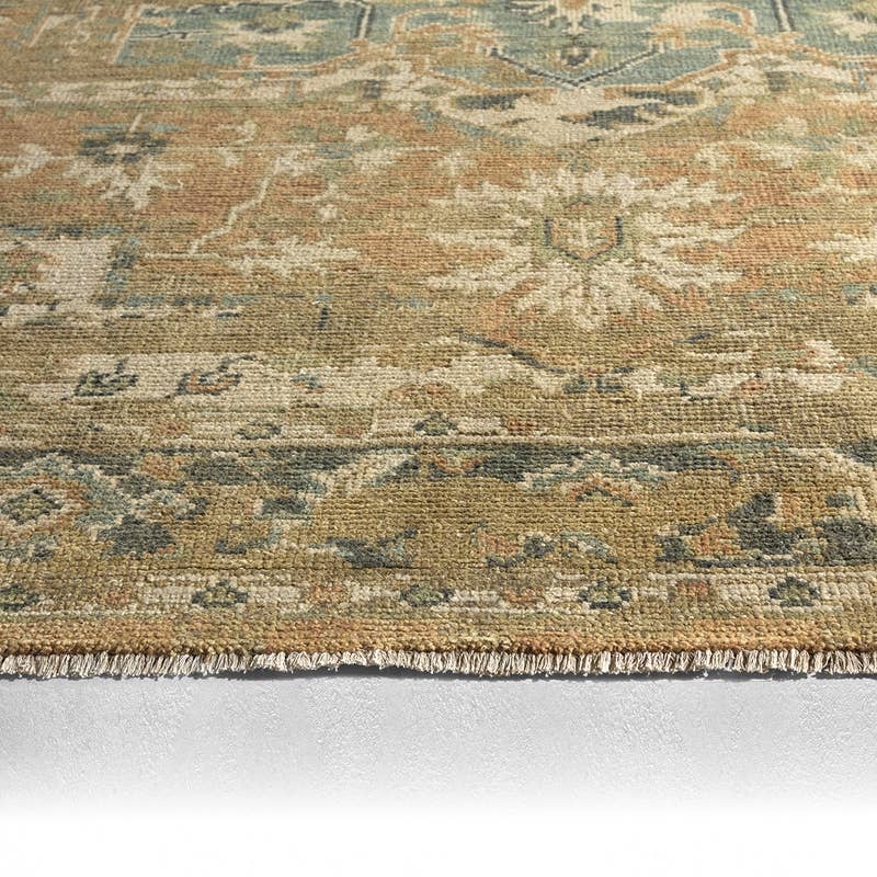 Rhapsody Orange hand-knotted wool and viscose rug with muted floral patterns and fringe.