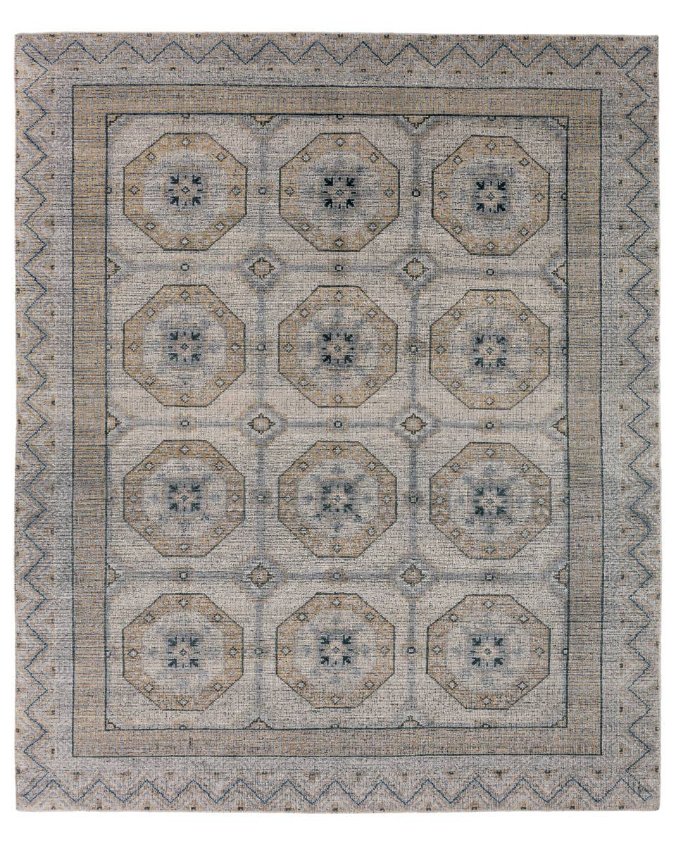 Rhapsody hand-knotted wool rug with a muted brown, grey, and blue geometric medallion pattern.
