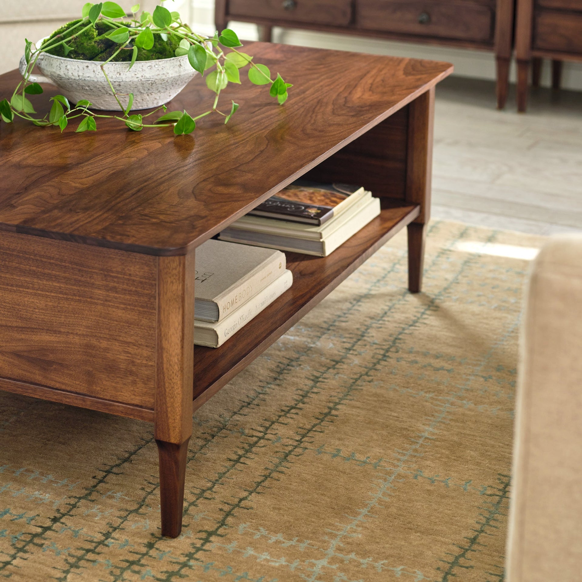Whipstitch Stickley wool rug in tan with a green plaid bamboo silk pattern under a wooden coffee table.